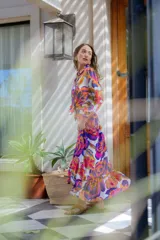 Falda larga evasé con estampado floral multicolor, cintura alta, cierre lateral y volado en el ruedo.
