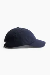 Gorra azul marino de sarga de algodón con ojales bordados, trabilla ajustable y cierre de metal atrás.