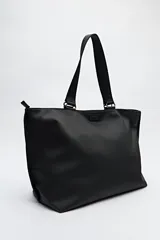 Bolso blanco de símil cuero con terminación suave. Tiene asas anchas de cinta negra y un bolsillo frontal con solapa.