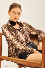 Camisa de manga larga con estampado de reptil, corte masculino y cuello camisero.