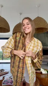 Camisa a cuadros en tonos tierra con apliques decorativos.