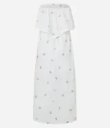 Vestido midi evasé sin mangas, confeccionado en tricolina color blanco, con escote recto con volantes y bordados metalizados de iconos.
