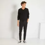 Sweater negro de punto liso, con cuello en V y mangas largas, de corte clásico.