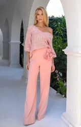 Pantalón de vestir color rosa, de corte recto y tiro alto, con detalle de flor en la cintura.