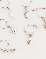 Set de tres pares de aros tipo argolla bañados en plata, con dijes colgantes de luna creciente con strass, rayo, estrella de ocho puntas, rombo con diseño floral y ojo con strass.
