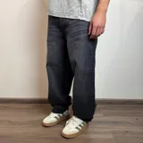 Pantalón jean negro de corte amplio y tiro medio.