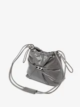 Bolso tipo cubo Diesel Scrunch-D color gris oscuro, confeccionado en cuero brillante con efecto arrugado. Presenta logo metálico "D" en el frente, cierre con cordones ajustables y correa de hombro extraíble.