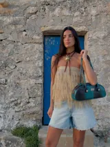 Cartera tipo baguette color marrón con asa corta con detalle de bolitas de madera.