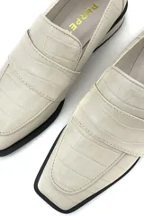 Mocasín color marfil de 100% cuero, con tacón de 3 cm y diseño elegante.