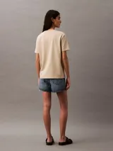Remera color beige de algodón con logo "Calvin Klein Jeans" estampado en blanco en el pecho.