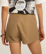 Bermuda color beige de corte sastrero, con hebilla en la cintura, diseño cruzado y bolsillos delanteros.