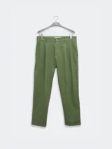 Pantalón de vestir color crema, confeccionado en tejido ligero de algodón con textura seersucker. Tiene corte recto, bolsillos laterales y traseros, cierre con botón y cremallera, y parche con logo de la marca.