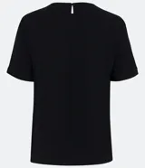 Blusa blanca de poliéster con cuello redondo, mangas cortas, cierre trasero en forma de gota, pequeñas aberturas laterales y acabados en pespuntes en las mangas y el cuello.