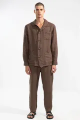 Pantalón marrón de lino 100% premium de alto gramaje, corte recto y fit relajado. Cintura con elástico y cordón de algodón, bolsillos laterales y traseros.