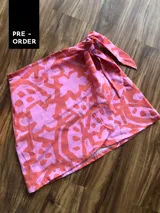 Minifalda pareo estampada en tonos rosa y naranja, con lazo lateral para atar.