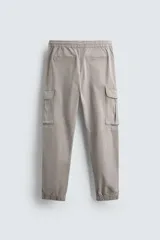 Pantalón cargo slim fit negro con cintura elástica ajustable con cordón, bolsillos frontales, traseros y laterales con solapa. Bajo con puño elástico.