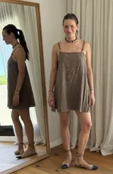 Vestido corto color marrón, con breteles finos, escote recto y bordado floral en el frente.