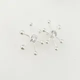 Caravana de diseño en forma de pulpo, elaborada en plata brillante con detalles en oro.