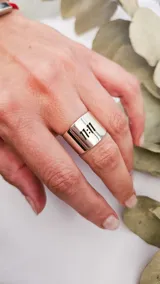 Anillo ancho de plata 925 con la inscripción "11:11" calada en el frente.