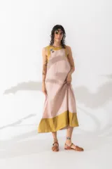 Vestido largo color borgoña con cuello redondo y sisas ribeteadas en rosa claro.
