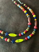 Collar corto con cuentas de cristal checo, cerámica, madera y otros materiales. Se cierra con cadena y ganchito para regular el largo.