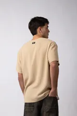 Remera color crudo de lino con textura entramada, calce cómodo y mangas cortas.