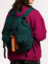 Mochila verde oscuro acolchada de nylon con correas negras en contraste y etiqueta naranja con el logo de la marca.