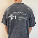 Remera gris con efecto lavado, corte oversize y estampado en la espalda con esqueleto de pez, texto y logos de la marca Underwave Brand.
