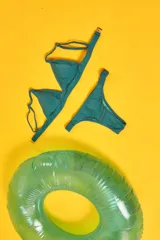 Conjunto de bikini blanco con textura, compuesto por un corpiño de triángulo fijo con breteles regulables y almohadillas desmontables, y una bombacha vedetina con frunce elástico en los costados.