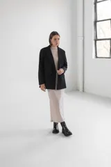 Blazer gris de corte clásico con solapas de muesca, cierre frontal con dos botones y bolsillos laterales con solapa.