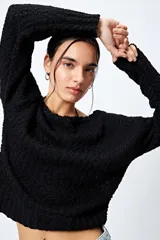 Sweater negro de punto texturado y calado, con cuello amplio y corte holgado.