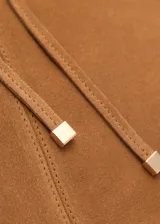 Bolso tipo shopper de gamuza color marrón, con doble asa corta y asa larga para el hombro. Tiene cierre de lazo y forro interior de algodón con un bolsillo con cremallera.