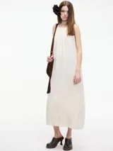 Vestido largo color crudo, de corte recto y breteles finos.