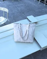 Bolso tote de cuero color bordó, con broche de cierre, bolsillo interior y porta llaves.