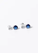 Par de caravanas plateadas con cierre a presión, con una zirconia azul redonda y una zirconia blanca redonda.