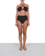 Top de bikini bandeau negro con breteles finos cruzados en la espalda y volados en los hombros.