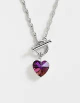 Cadena corta plateada con dije de corazón facetado con degradé de color fucsia a naranja.