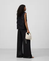 Pantalón negro de tiro alto, pierna muy ancha y caída fluida, confeccionado en tejido satinado de poliéster reciclado.