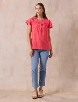 Blusa blanca de tejido pointelle con manga corta con volados y cuello redondo.