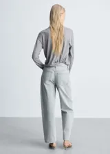 Cárdigan gris de tejido de punto fino con cuello pico, manga larga y cierre frontal con botones.