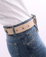 Cinturón de cuero color beige con hebilla ovalada y apliques metálicos color bronce.