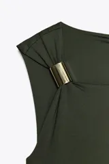 Vestido midi marrón de punto, con cuello asimétrico, manga sisa y aplique metálico en el hombro. Presenta un drapeado lateral.