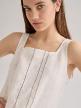 Musculosa blanca de lino con escote cuadrado y detalle de pespuntes verticales en el frente.
