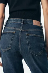Pantalón de jean negro de corte recto, tiro alto y largo tobillero.