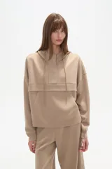 Buzo negro con capucha, cuello alto con broches, manga larga y bolsillo canguro frontal.