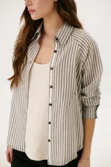 Camisa a rayas verticales color beige y blanco, con cuello clásico, botones marrones y mangas largas.