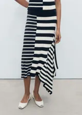 Falda midi de punto con estampado de rayas horizontales en blanco y negro. Presenta cintura elástica, corte evasé y bajo asimétrico.