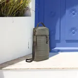 Matera verde militar con detalles en cuero color suela, con correa de galón regulable y manija superior. Cuenta con bolsillo interior con cierre y compartimiento apto para termos de 1000 ml de capacidad.