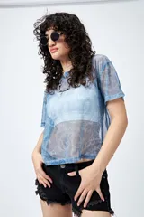 Top translúcido azul con estampado abstracto, de manga corta y tejido liviano con sutil brillo metálico.
