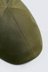 Boina negra con visera confeccionada en tejido con algodón y lino.